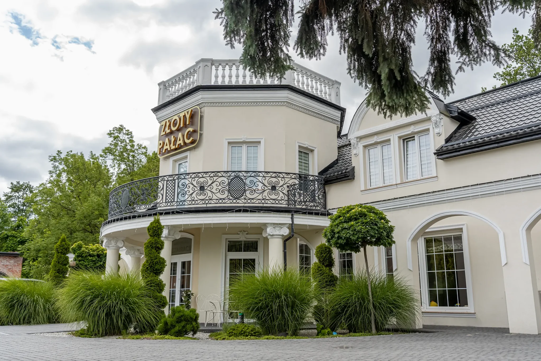 Złoty Pałac ujęty pod kątem: wieża z szyldem i prawe skrzydło budynku